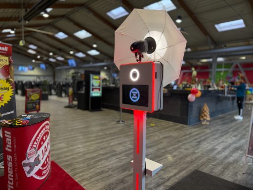 Ein Fotoautomat mit Beleuchtung in einer großen, hellen Halle.